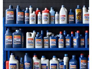 Shelves in a garage neatly stocked with automotive oils, car care products, and spare parts